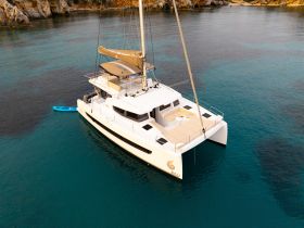 A stunning aerial view of a sleek catamaran anchored in crystal-clear waters, perfect for luxury sailing adventures and island hopping.