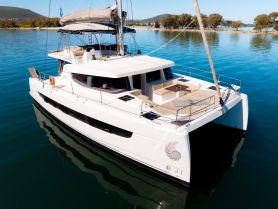 A stunning aerial view of a sleek catamaran docked in calm waters, showcasing its modern design and spacious deck — perfect for luxury sailing adventures.
