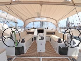 A spacious and well-designed helm area of a sailboat, featuring comfortable seating and modern controls, perfect for navigating the open waters.