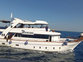 A lively scene aboard the Danube boat with guests enjoying the cruise on open waters — perfect for group outings and scenic adventures.