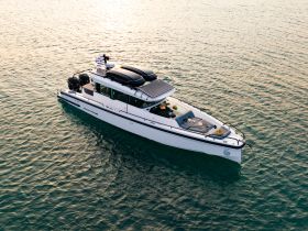 A stunning aerial view of a sleek yacht cruising through calm waters, showcasing its modern design and features — perfect for luxury boating experiences.