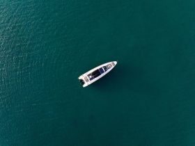 Aerial view of a sleek yacht cruising through calm turquoise waters, showcasing its elegant design and perfect for luxury outings.