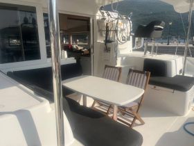 A cozy interior view of a boat's dining area featuring comfortable seating and a table, perfect for relaxing meals while enjoying the water.