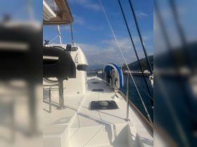 A view of the helm area on a sleek yacht, showcasing the modern console and spacious deck, perfect for navigating the open waters.