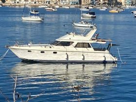 A beautiful yacht docked in calm waters, showcasing its elegant design against a picturesque backdrop of the harbor.