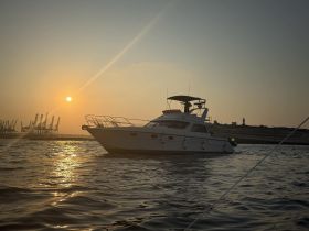A stunning sunset view of a yacht gently floating on the water, showcasing its elegant profile against the backdrop of a serene evening sky.