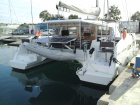 A sleek catamaran docked at the marina, showcasing its modern design and spacious layout, perfect for leisurely cruises or group charters.