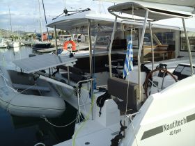 A detailed view of a Nautitech 40 Open catamaran docked at the marina, showcasing its sleek design and solar panel setup.