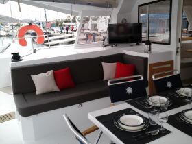 Interior view of a stylish boat cabin featuring comfortable seating and a dining area, perfect for relaxing and enjoying meals while on the water.