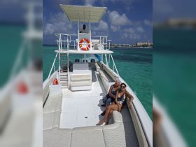 Two women relax on the deck of a boat, enjoying the sunny ocean views — a perfect moment for a day out on the water.