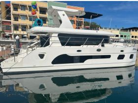 A sleek yacht docked at the marina, showcasing its modern design and reflections in the calm waters — perfect for luxury charters and waterfront views.