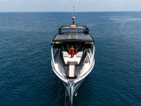 A stunning aerial view of a luxurious yacht with a guest on deck, showcasing the perfect setting for a memorable day on the water.