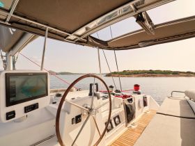 A well-equipped helm of a sailboat featuring a modern navigation system and comfortable seating, perfect for enjoying a day on the water.
