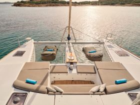 A serene view of the lounge area on a catamaran, featuring comfortable seating and a relaxing atmosphere, perfect for unwinding while enjoying the beautiful waters.