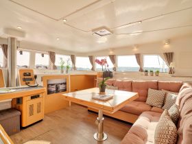 A cozy and well-designed interior of a boat featuring comfortable seating and a helm area, perfect for relaxing during a voyage.