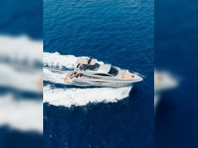A stunning aerial view of a sleek yacht cruising through deep blue waters, showcasing its elegant design and perfect for luxury charters.