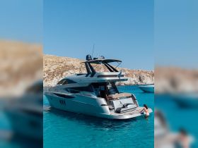 A woman enjoys a refreshing dip next to a luxurious yacht in crystal-clear waters, showcasing the perfect blend of relaxation and adventure on the high seas.