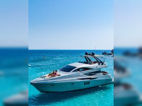 A couple enjoys sunbathing on the deck of a luxurious yacht in stunning turquoise waters, perfect for a relaxing day on the sea.