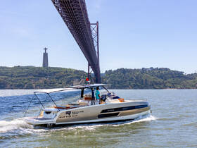 A sleek boat cruises under a stunning bridge, with a prominent landmark in the background, showcasing the beauty of the waterway and the vibrant scenery.