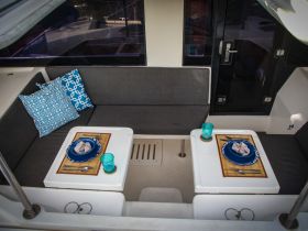 An inviting dining area inside a boat, featuring stylish seating and a beautifully set table, perfect for enjoying meals on the water.