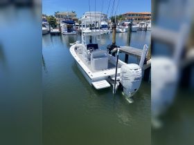 A sleek center console boat docked in calm waters, showcasing its modern design and fishing capabilities, perfect for a day on the water.