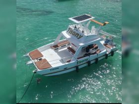 Aerial view of the Tisony catamaran anchored in crystal-clear waters, showcasing its spacious deck and modern design, perfect for leisurely outings.