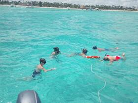 A group of snorkelers explores the vibrant underwater world in crystal-clear turquoise waters, perfect for family adventures and aquatic fun.