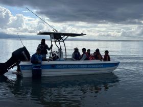 A lively group enjoys a boat tour in Golfo Dulce, Costa Rica, with stunning views and fishing opportunities — perfect for family adventures on the water.