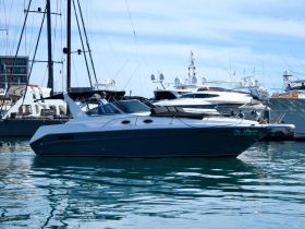 A sleek yacht named 'My Dream' is docked in a marina, showcasing its elegant design against a backdrop of other vessels.