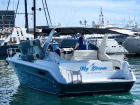 A sleek speedboat named 'My Dream' docked in a marina, showcasing its stylish design and inviting atmosphere for water adventures.