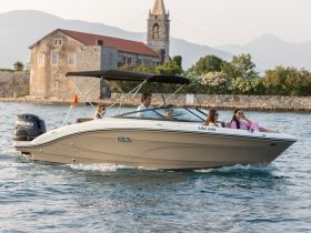 A group enjoys a scenic boat ride, showcasing the beauty of the surroundings while having fun on the water.