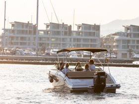 A group enjoys a scenic boat ride at sunset, creating a perfect backdrop for memorable moments on the water.
