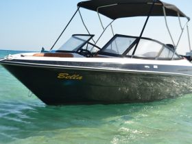 A sleek boat named 'Bella' glides through clear waters, showcasing its elegant design and perfect for leisurely outings.