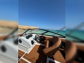 A well-designed helm area of a boat featuring a comfortable seating arrangement and modern controls, perfect for navigating the open waters.