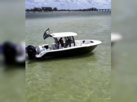 A boat navigates through clear waters with a person on board, showcasing a perfect day for boating adventures.