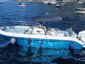 A sleek speedboat anchored in clear blue waters, showcasing its elegant design and vibrant colors, perfect for a day on the water.