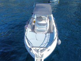 Aerial view of a sleek speedboat anchored in clear blue waters, showcasing its modern design and spacious deck — perfect for day trips and water adventures.