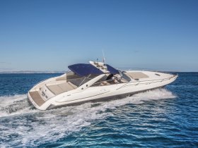 A sleek speedboat cuts through the clear blue waters, showcasing its elegant design and performance while underway.