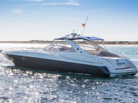 A sleek speedboat named 'Watch Me' glides through sparkling waters, showcasing its elegant design and perfect for thrilling adventures on the sea.