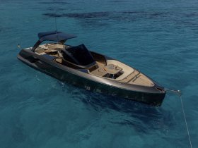 A stunning aerial view of a sleek yacht gliding through crystal-clear waters, showcasing its elegant design and luxurious features.