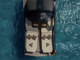 Aerial view of a luxurious lounge area on a boat, featuring comfortable seating and plush cushions, perfect for relaxing on the water.