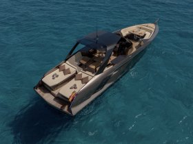 A stunning aerial view of a sleek yacht cruising through crystal-clear waters, showcasing its elegant design and luxurious seating.