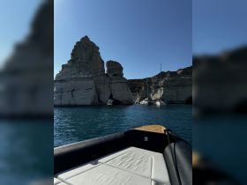 A stunning view of rocky cliffs and serene waters, showcasing the beauty of the coastline from a boat — perfect for exploring picturesque destinations.