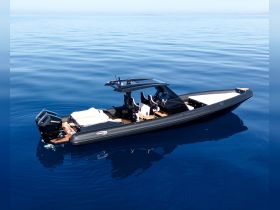 A sleek speedboat glides through calm blue waters, showcasing its modern design and perfect for thrilling adventures on the sea.