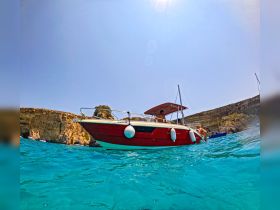 A vibrant scene featuring a boat anchored in crystal-clear waters, with people enjoying the summer sun — perfect for a day of relaxation and adventure on the water.