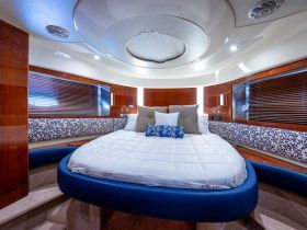 A beautifully designed cabin interior featuring a spacious circular bed and elegant wood finishes, perfect for relaxation on a luxury yacht.