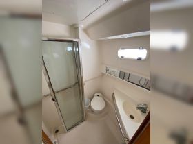 A clean and modern bathroom interior on a boat, featuring a shower, toilet, and sink — ideal for comfortable cruising.
