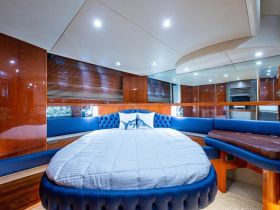 A beautifully designed cabin interior featuring a round bed and plush seating, perfect for relaxation on a luxury yacht.