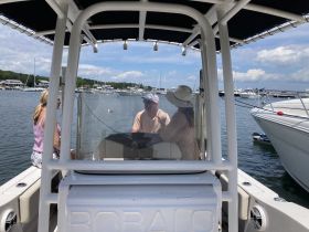 A group of friends engages in conversation aboard a boat, enjoying a sunny day at the marina — perfect for social outings and leisurely trips on the water.