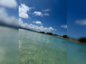 A scenic view of clear waters and a bright blue sky, capturing the serene beauty of a tropical destination.